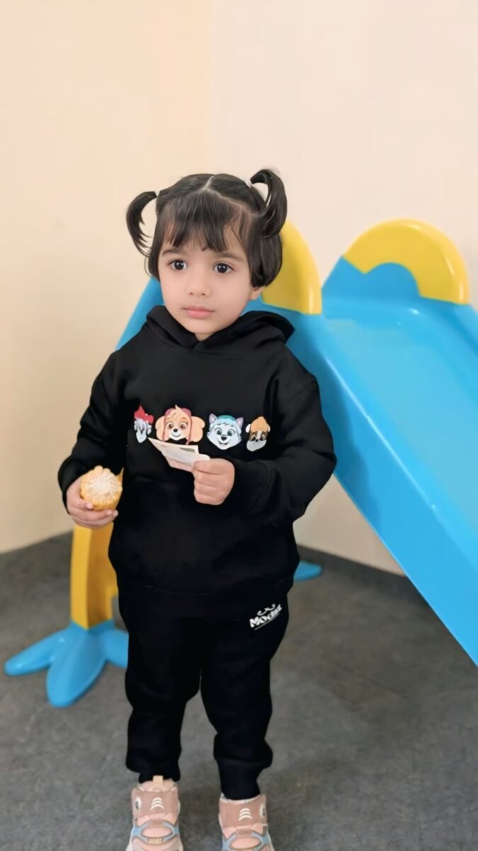 Toddler wearing a black MODST character hoodie set at a playground