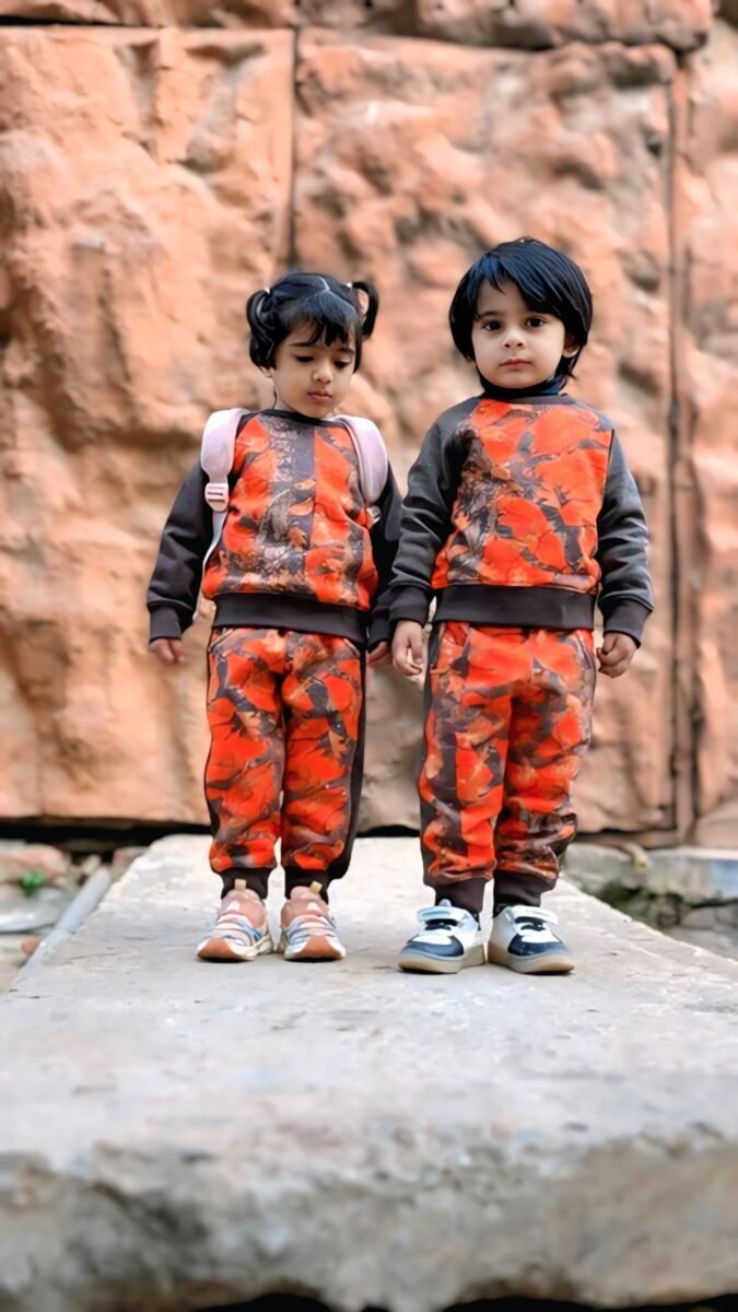 Two children wearing orange camo MODST track suits